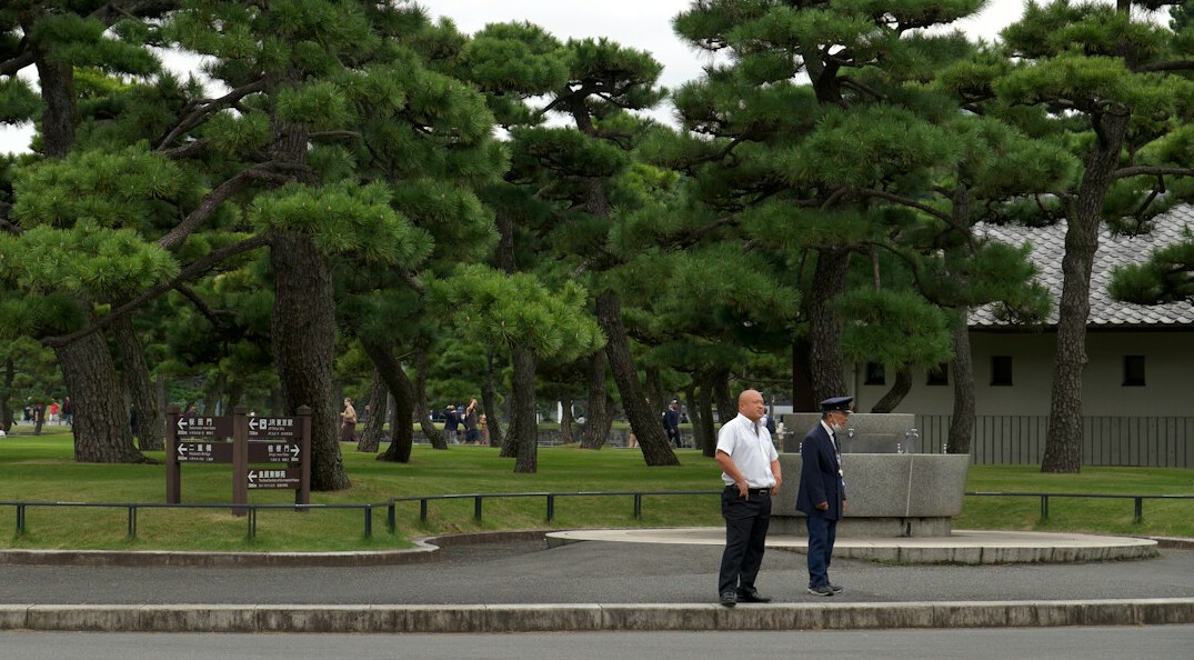Group of active Japanese seniors laughing together outdoors in a park